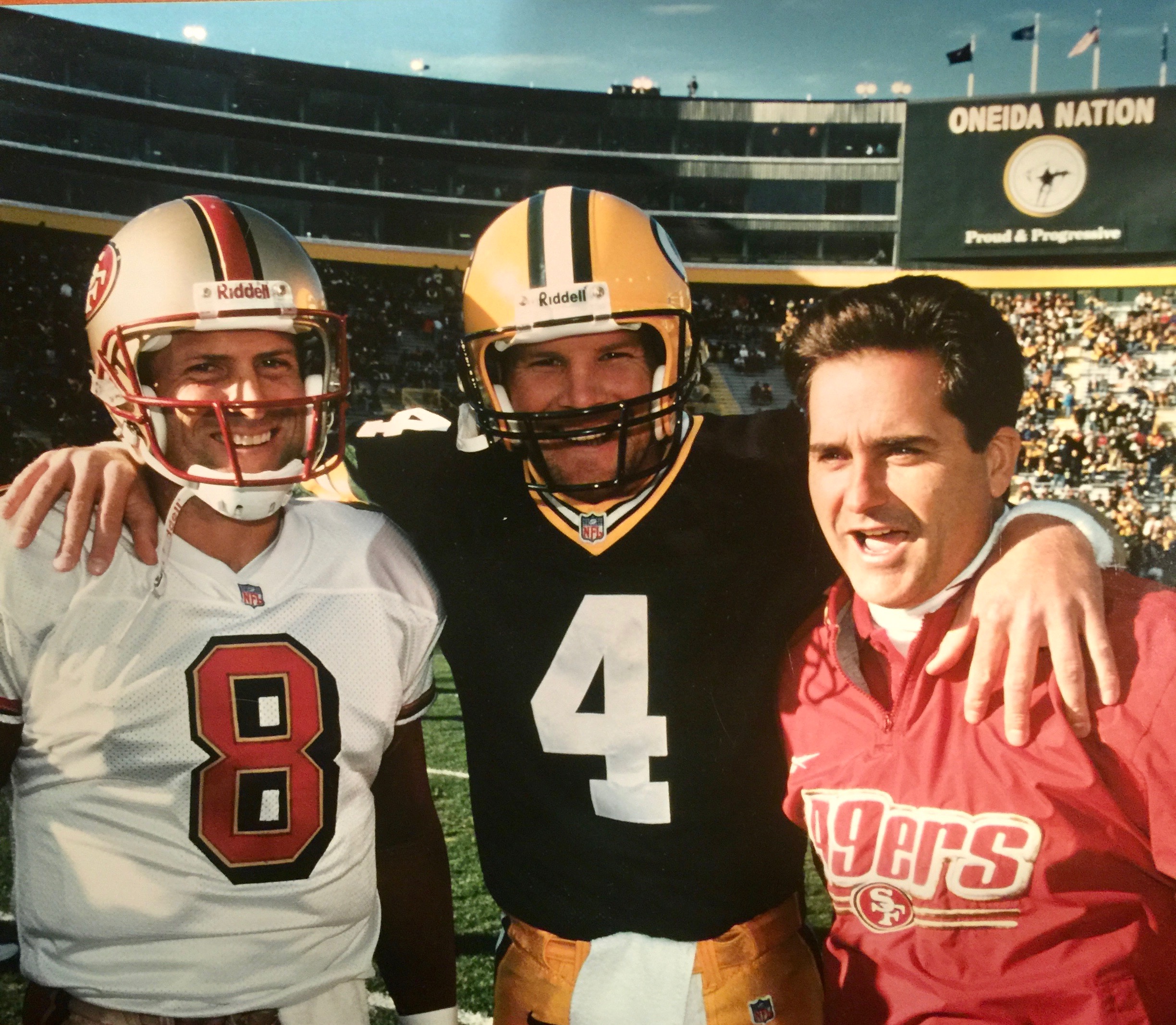 Head coach Mariucci with his 49ers quarterback Steve Young and Packers quarterback Brett Favre, whom he used to coach as an assistant in Green Bay.