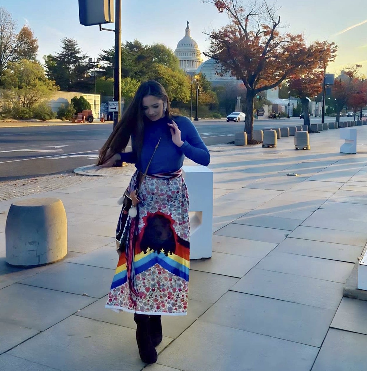 Diehlman in a ribbon skirt and yarn belt before the before the White House Tribal Youth Forum.