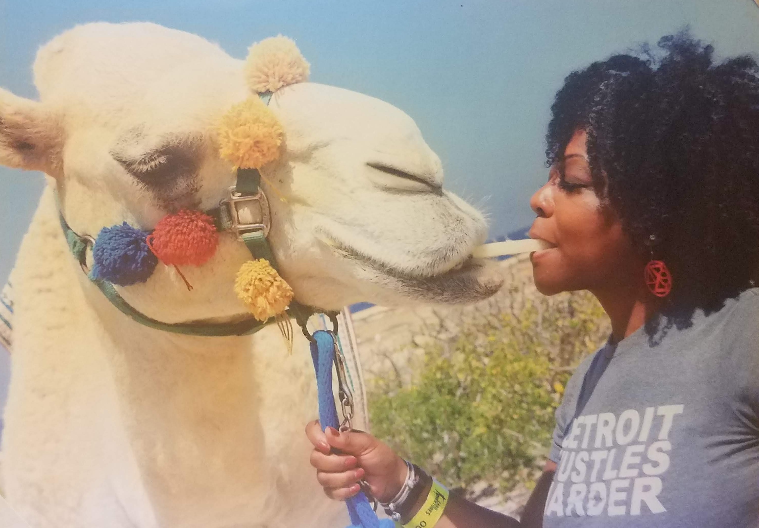 Feeding a camel in Mexico wearing her "Detroit Hustles Harder" t-shirt