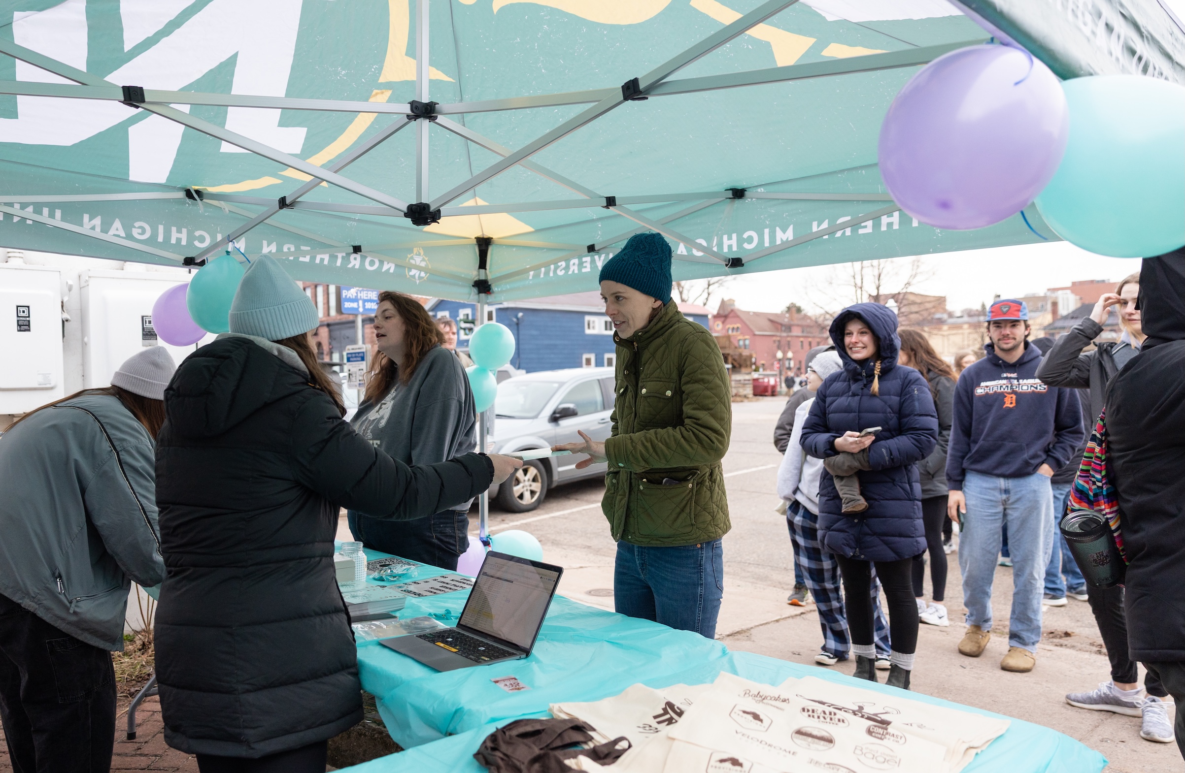 Participants line up outside Dead River Coffee to register for the event and pick up their passports (below)
