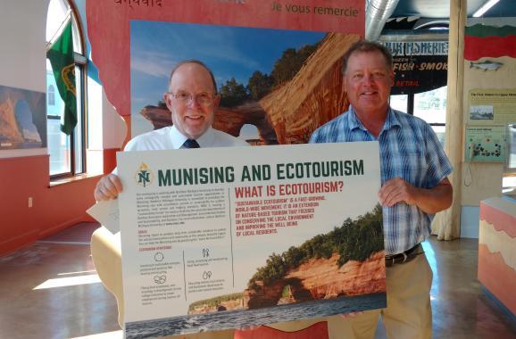 Image of President Fritz Erickson delivering ecotourism display piece to NMU alumnus John Madigan