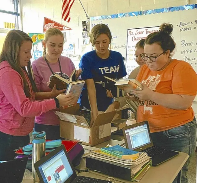 Students in Townsend's classroom review the books donated by NMU.