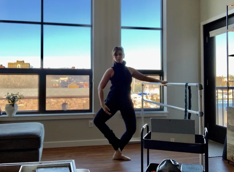 Grundstrom in a living room teaching students connected via the computer in front of her.