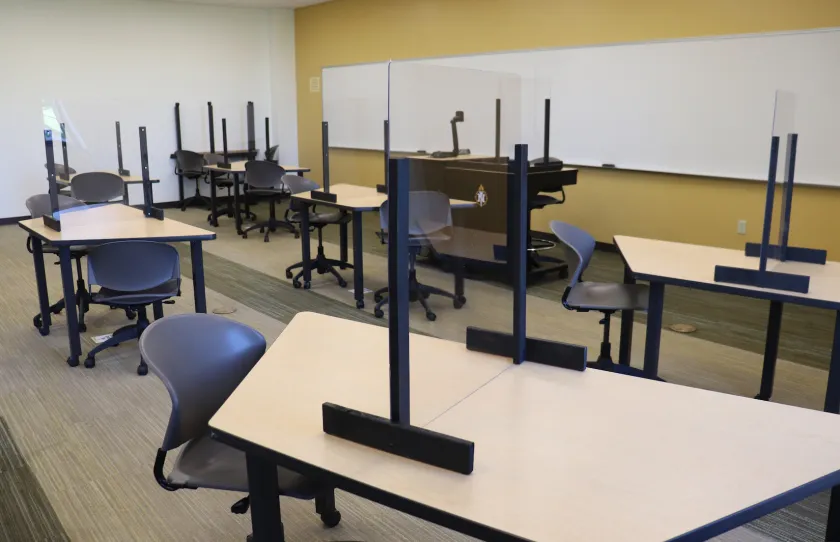 Classroom with plexiglas barriers on tables