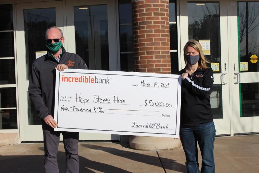 Robb Winn of NMU and the UMBTC receives a title sponsorship check from Ashley Cody of IncredibleBank.