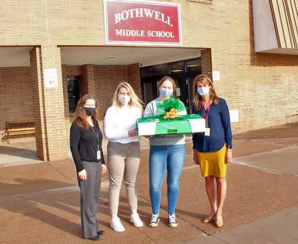 NMU students Sydney Wickstrom and Mackenzie Meyer (second and third from left) make a delivery to Bothwell personnel.
