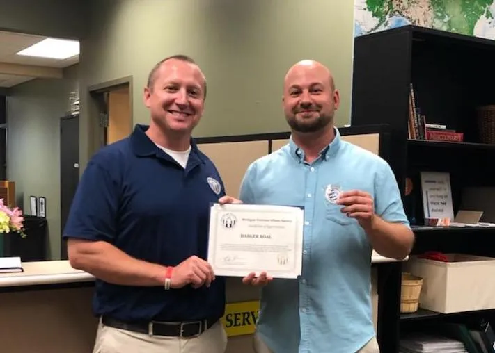 Engle (left) presents the coin and certificate to Boal