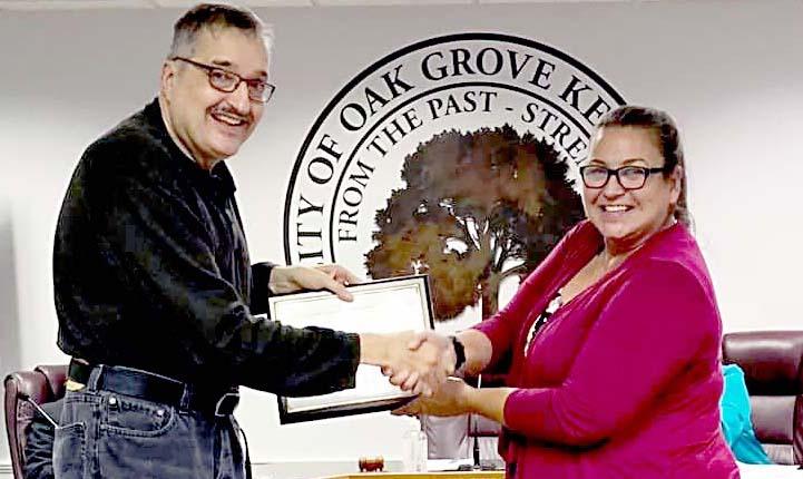 Cook (left) receives the award from Oak Grove Mayor Theresa Jarvis.