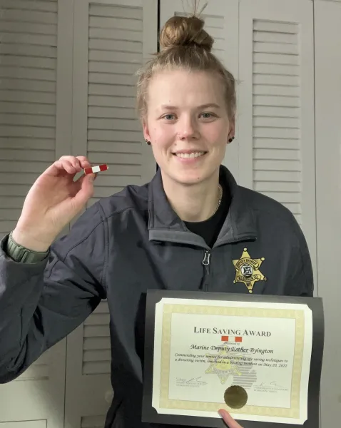 Esther Byington with her lifesaving certificate and pin (later replaced with a medal)