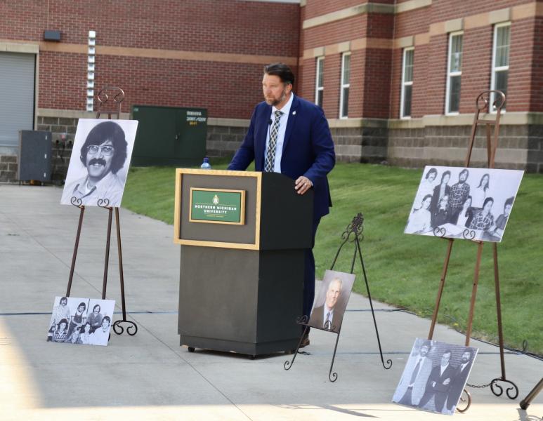 Jeff Korpi speaks at the dedication, surrounded by photos of Holm.