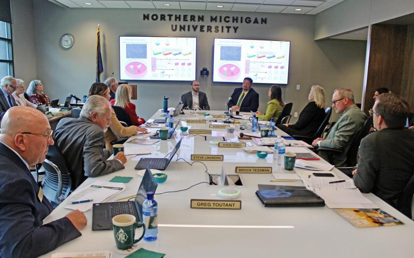 Alex Wilson and Matthew Jennings (back center) give a presentation to the NMU Board of Trustees