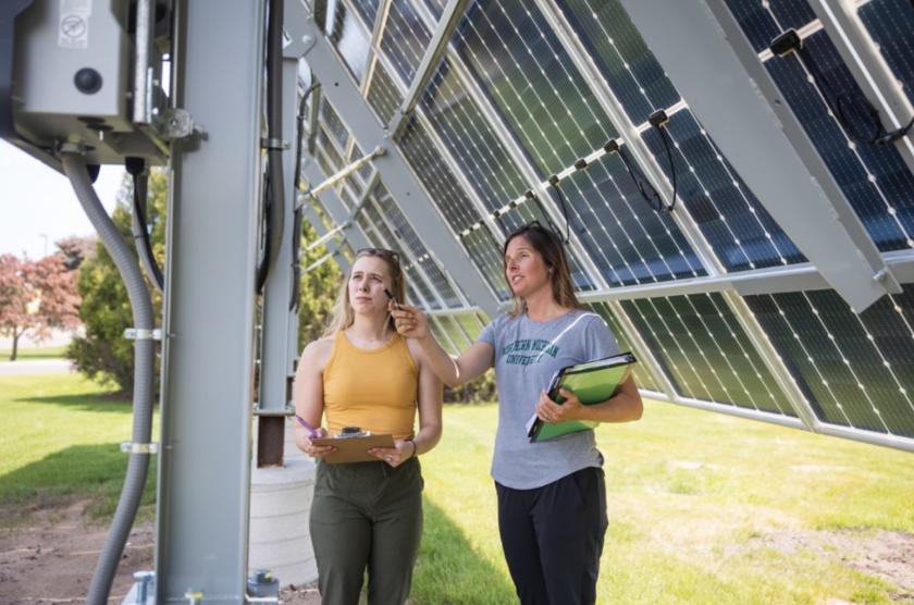 Jes Thompson (right) and a student by the solar array installed on campus.