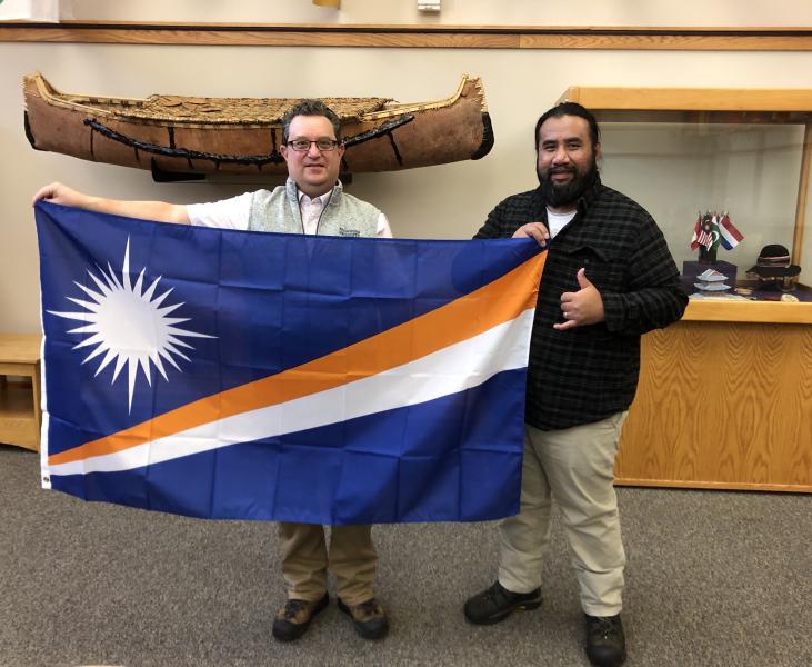 Alik (right) presents the flag to NMU's Joe Lubig.