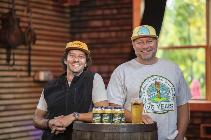 Left to right: NMU alumni Steve Farr (’09 BS, ’12 MBA), Blackrocks' "Pirate of Propoganda" and Andy Langlois ('95 BS), Blackrocks co-owner, with the branded Wildcat Gold Lager cans.