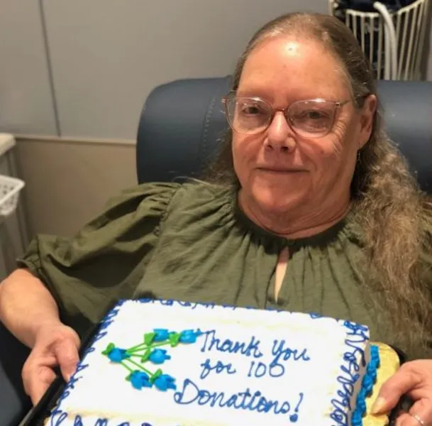 Grace Albert with the cake marking her 100th blood donation (U.P. Regional Blood Center photo)