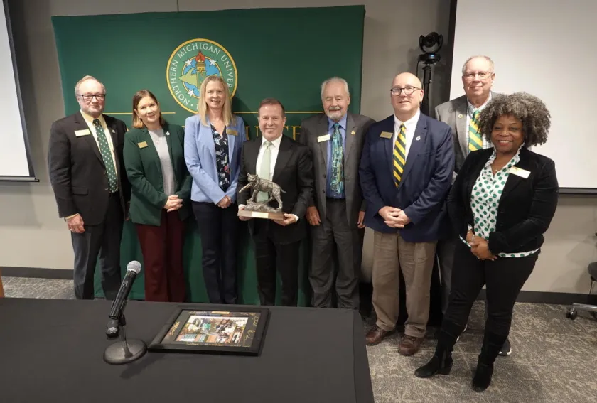 Gavin Leach (center, with Wildcat statue) was honored for his leadership of NMU the past six months by Trustees (from left): Steve Young, Lisa Fittante, Missie Holmquist, Steve Lindberg, Greg Toutant, Greg Seppanen and Venus Joy Brown.