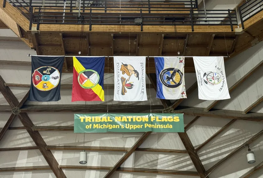 The flags representing the five U.P. tribal nations are suspended from a Superior Dome rafter