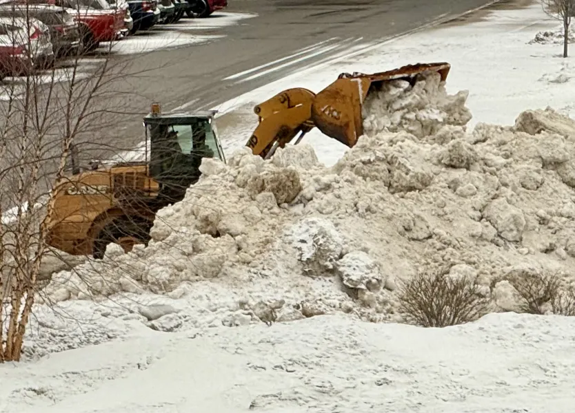 A front-end loader moves snow in the Northern Center parking lot in advance of today's storm.