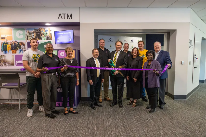 NMU and Collegiate and AlumniFi representatives pose for a ribbon cutting