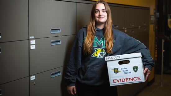 Student Autumn Combs with a box of case materials