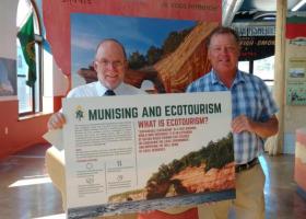 Image of President Fritz Erickson delivering ecotourism display piece to NMU alumnus John Madigan