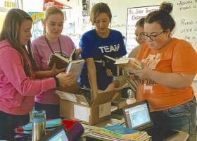 Students in Townsend's classroom review the books donated by NMU.