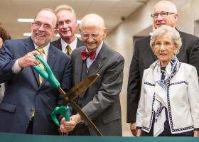 June Jamrich (far right) watches as NMU President Fritz Erickson and former President John X. Jamrich cut the ribbon for the new Jamrich Hall dedication in 2014.