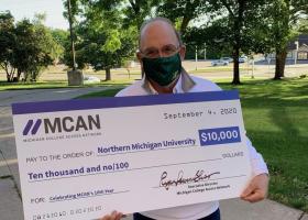 NMU President Fritz Erickson with the ceremonial check
