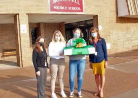 NMU students Sydney Wickstrom and Mackenzie Meyer (second and third from left) make a delivery to Bothwell personnel.
