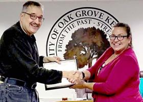 Cook (left) receives the award from Oak Grove Mayor Theresa Jarvis.