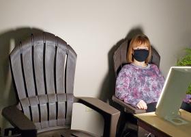 NMU student employee Raija Stille tries out one of the chairs near the sun lamp.