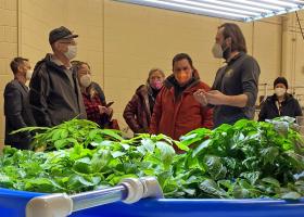 McDowell (front left) listens to NMU Assistant Professor Evan Lucas during a tour of the indoor agriculture lab. (Dave Nyberg photo)
