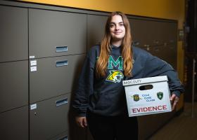 Student Autumn Combs with a box of case materials