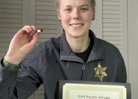 Esther Byington with her lifesaving certificate and pin (later replaced with a medal)