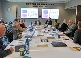 Alex Wilson and Matthew Jennings (back center) give a presentation to the NMU Board of Trustees