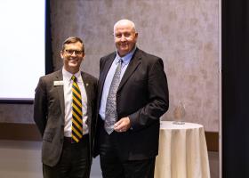 Charles Hawes accepts the Alumni Service Award from NMU President Brock Tessman