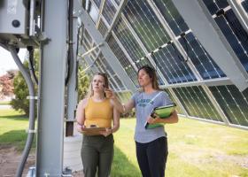 Jes Thompson (right) and a student by the solar array installed on campus.