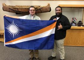 Alik (right) presents the flag to NMU's Joe Lubig.