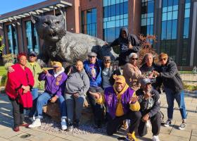 Reunion attendees pose for a photo in front of the Wildcat statue.