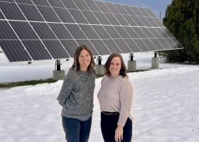 Jes Thompson (left) and Anna Solberg in front of the solar array on campus.