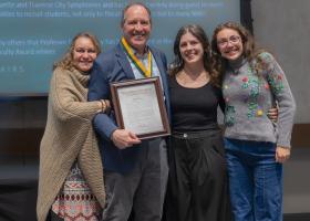 Truckey wearing his award medal and surrounded by his family