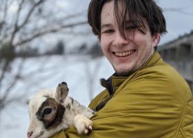 Tucker McLain holding a baby goat named Little Snickers.