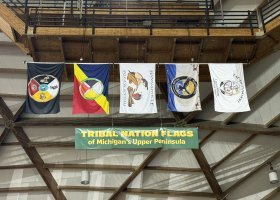 The flags representing the five U.P. tribal nations are suspended from a Superior Dome rafter