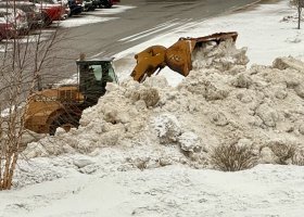 A front-end loader moves snow in the Northern Center parking lot in advance of today's storm.