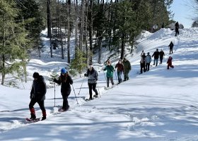 Participants begin their snowshoe to the maple trees