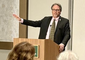 Olsen addressing attendees at the university forum.