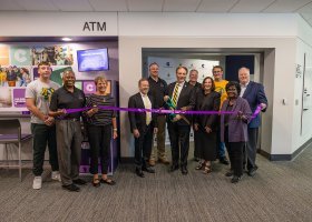 NMU and Collegiate and AlumniFi representatives pose for a ribbon cutting