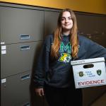 Student Autumn Combs with a box of case materials