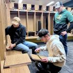 (From left): Kyle Sahr, Trent Kantola and Luke Pettinger installing locker shelves.