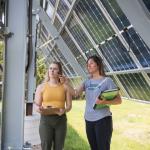 Jes Thompson (right) and a student by the solar array installed on campus.